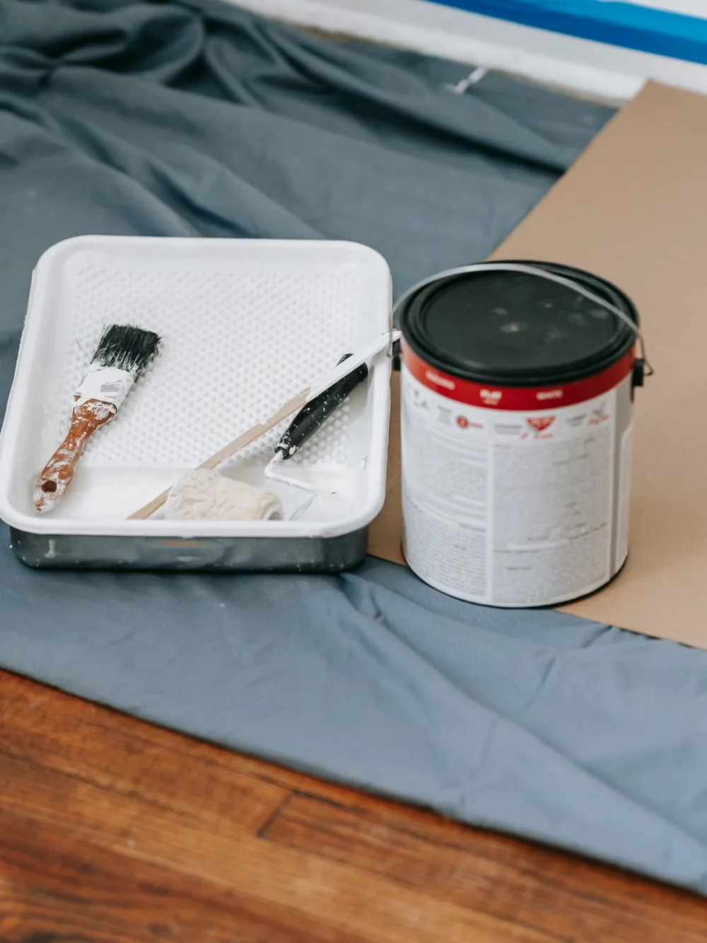 Matériel de peinture posé sur une bâche de protection.